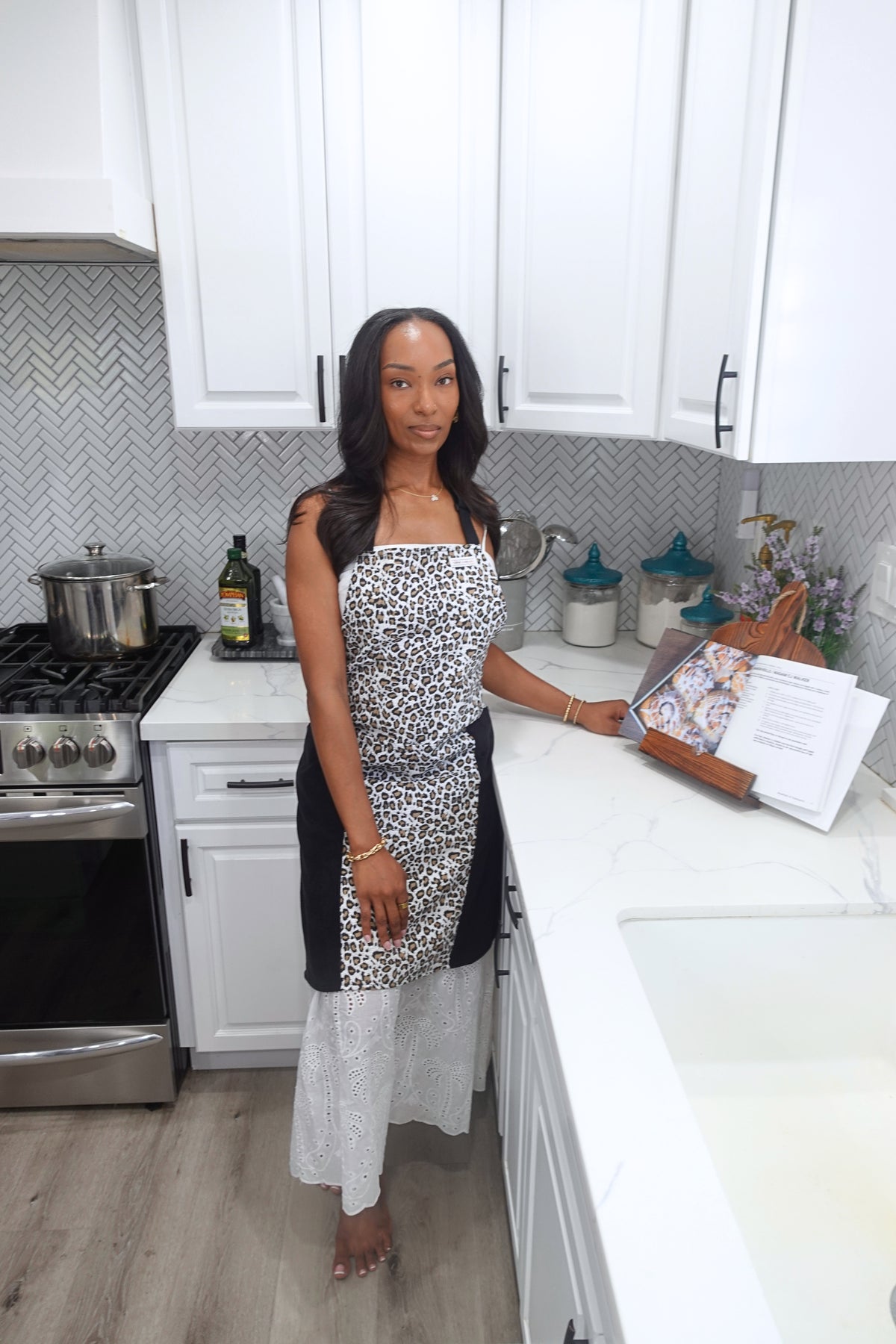 Woman wearing Safari leopard print baking apron with black microfiber towel panels in a kitchen